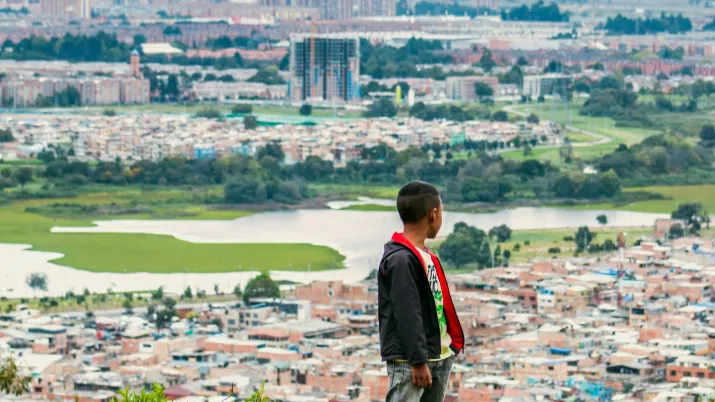 Un jeune garçon regarde la ville de Bogota.